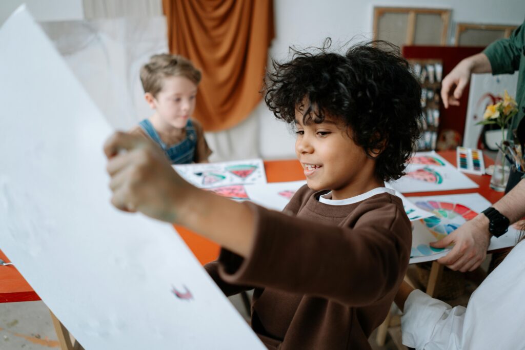 pexels-photo-7898625-7898625 Two children joyfully painting in an art class, expressing creativity and learning.